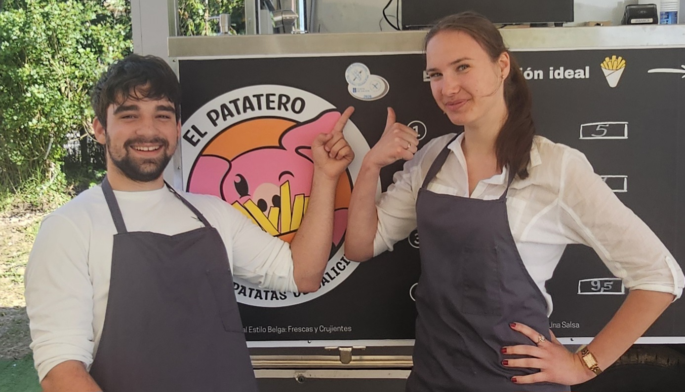Dos integrantes del equipo de El Patatero junto al logotipo